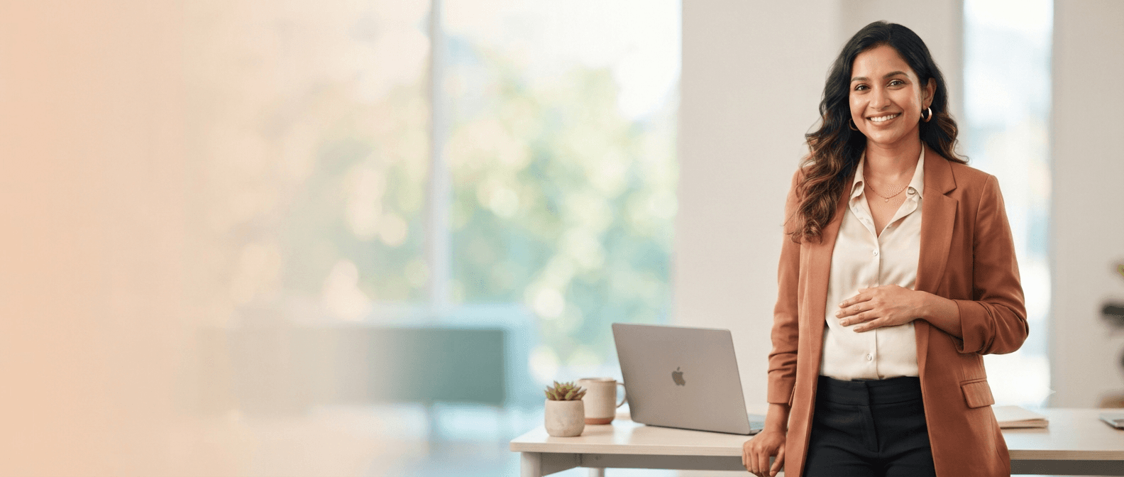 Pregnant professional standing beside her desk