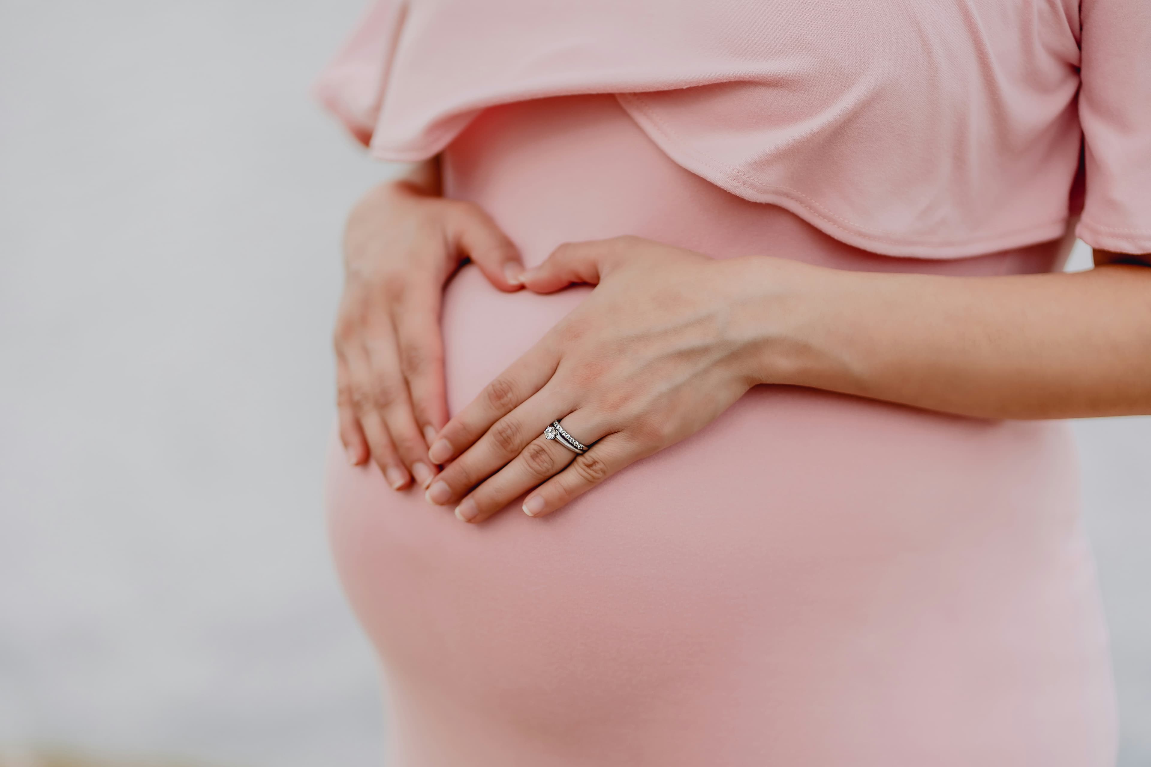 Pregnant mother gently holding her belly