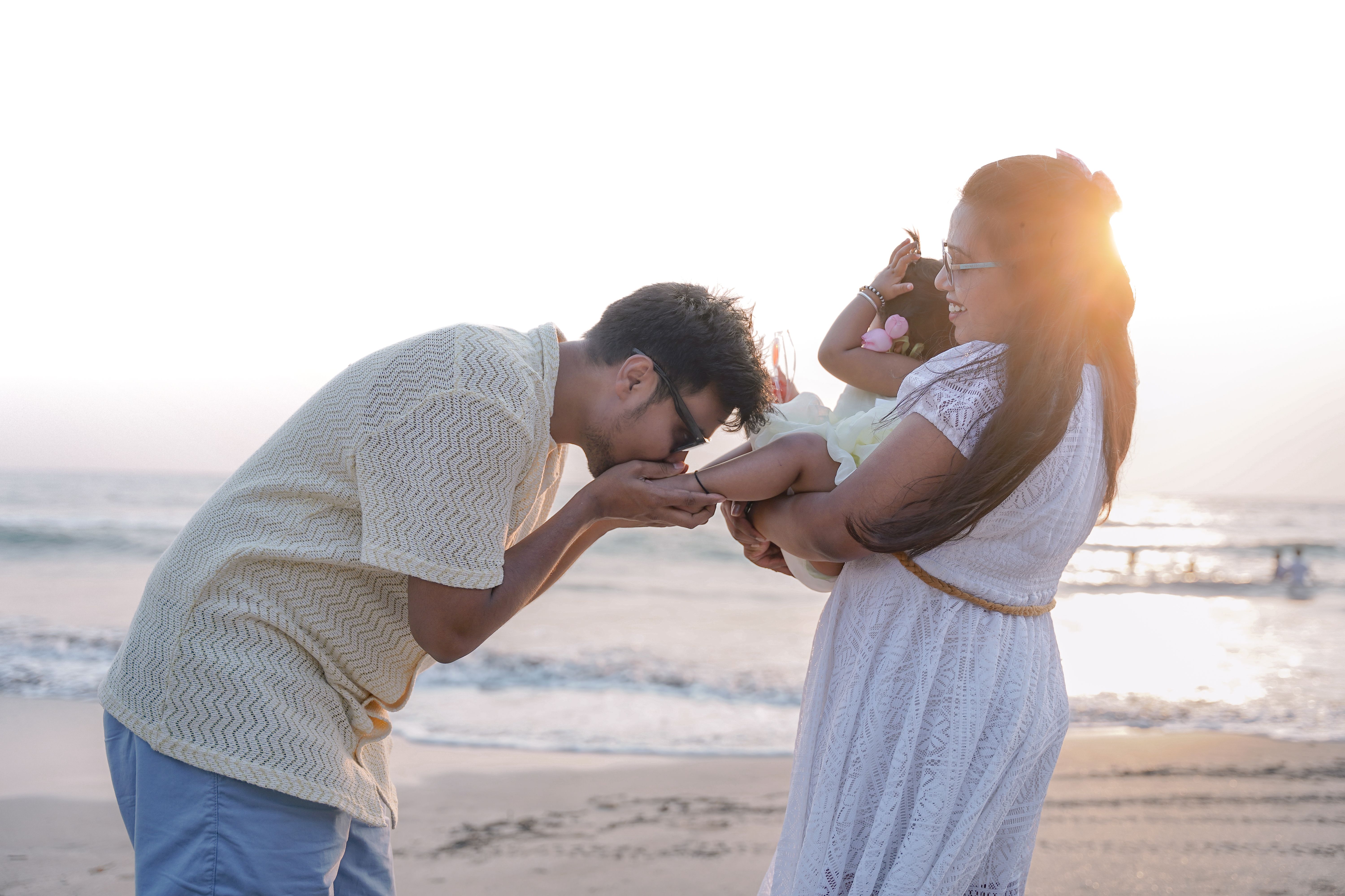 A young couple holding and kissing their newborn